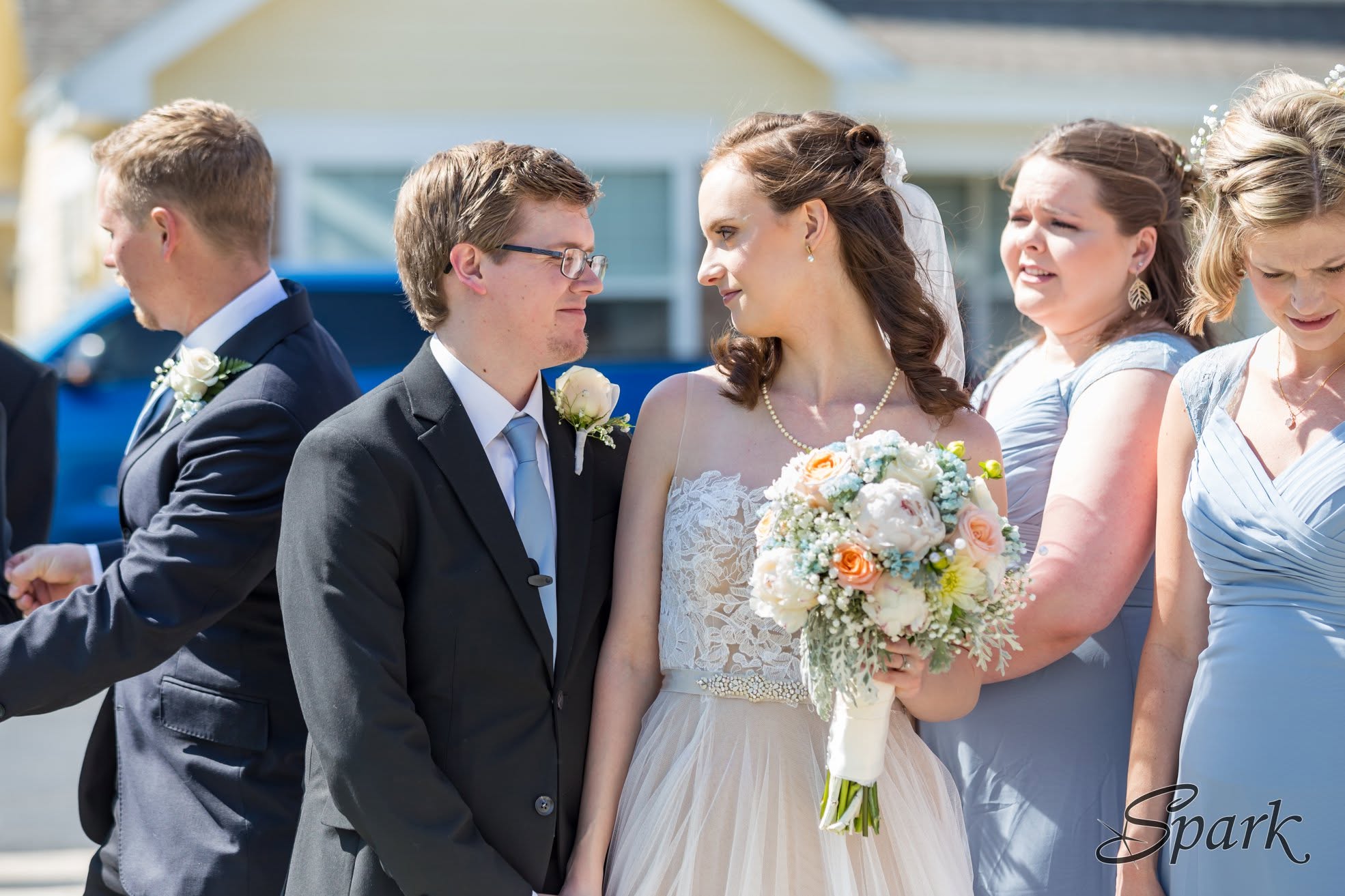 Bride and groom smiling together with their wedding party