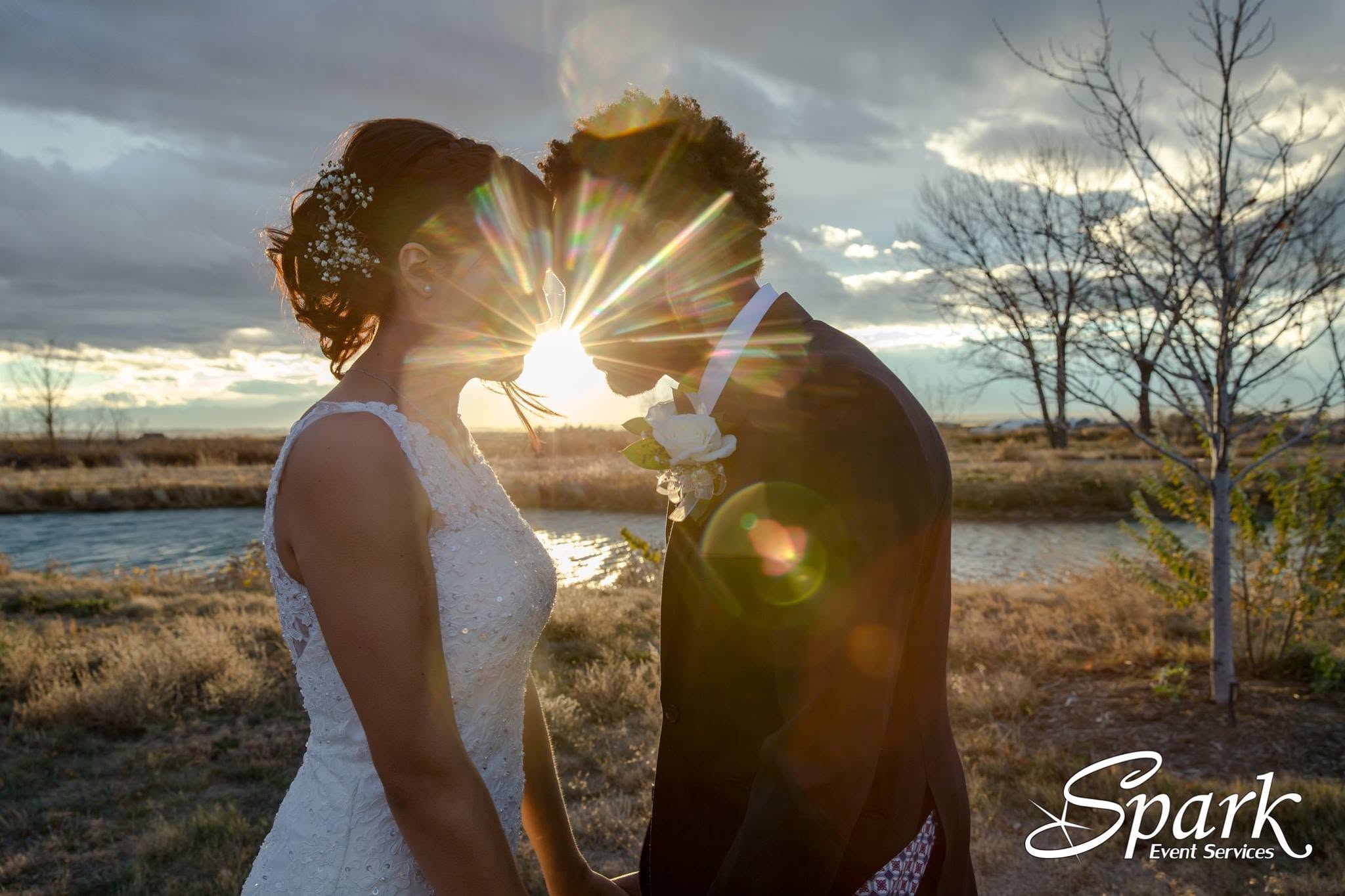 Newlyweds sharing a kiss in golden evening light